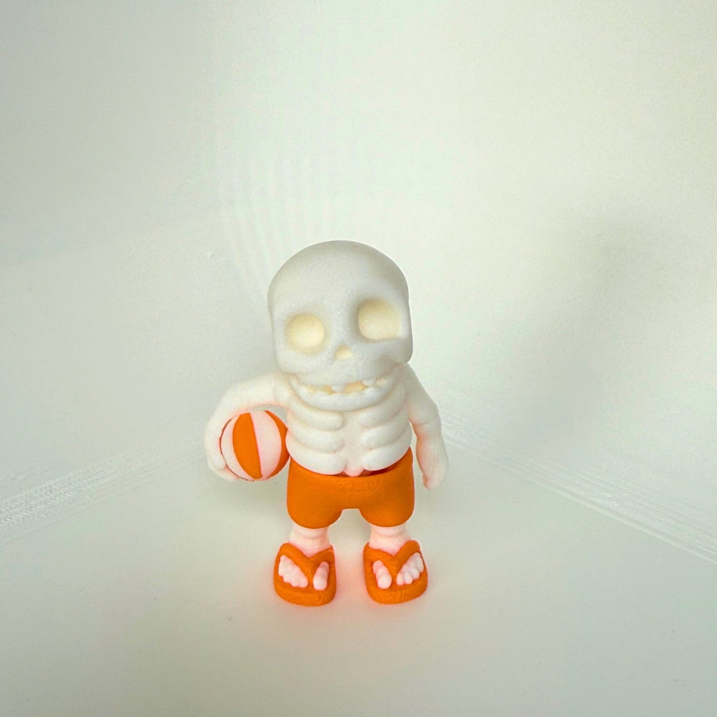 Articulated skeleton beach toy with orange shorts and sandals, perfect for summer fun – eco-friendly and child-safe
