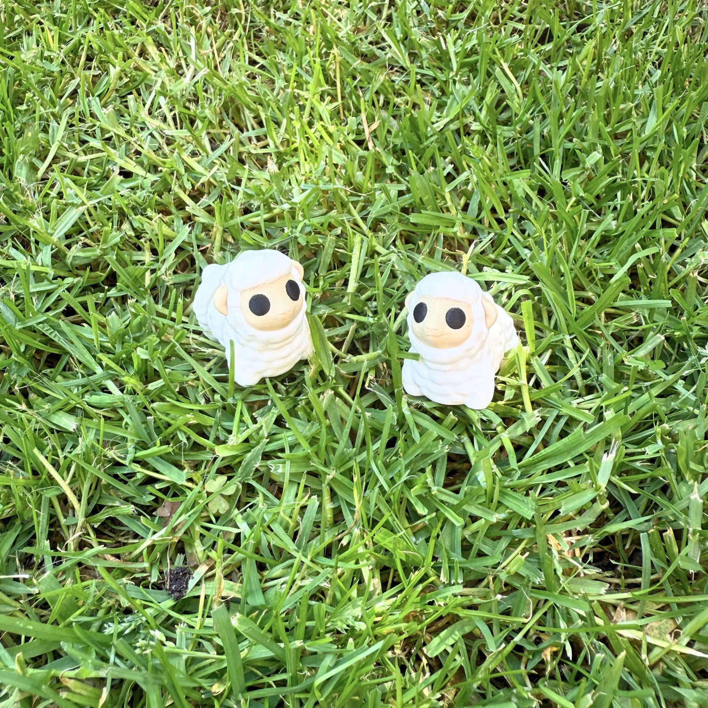 Flexibel model van twee 3D geprinte schaapjes in het gras, speelgoed met beweegbare delen.