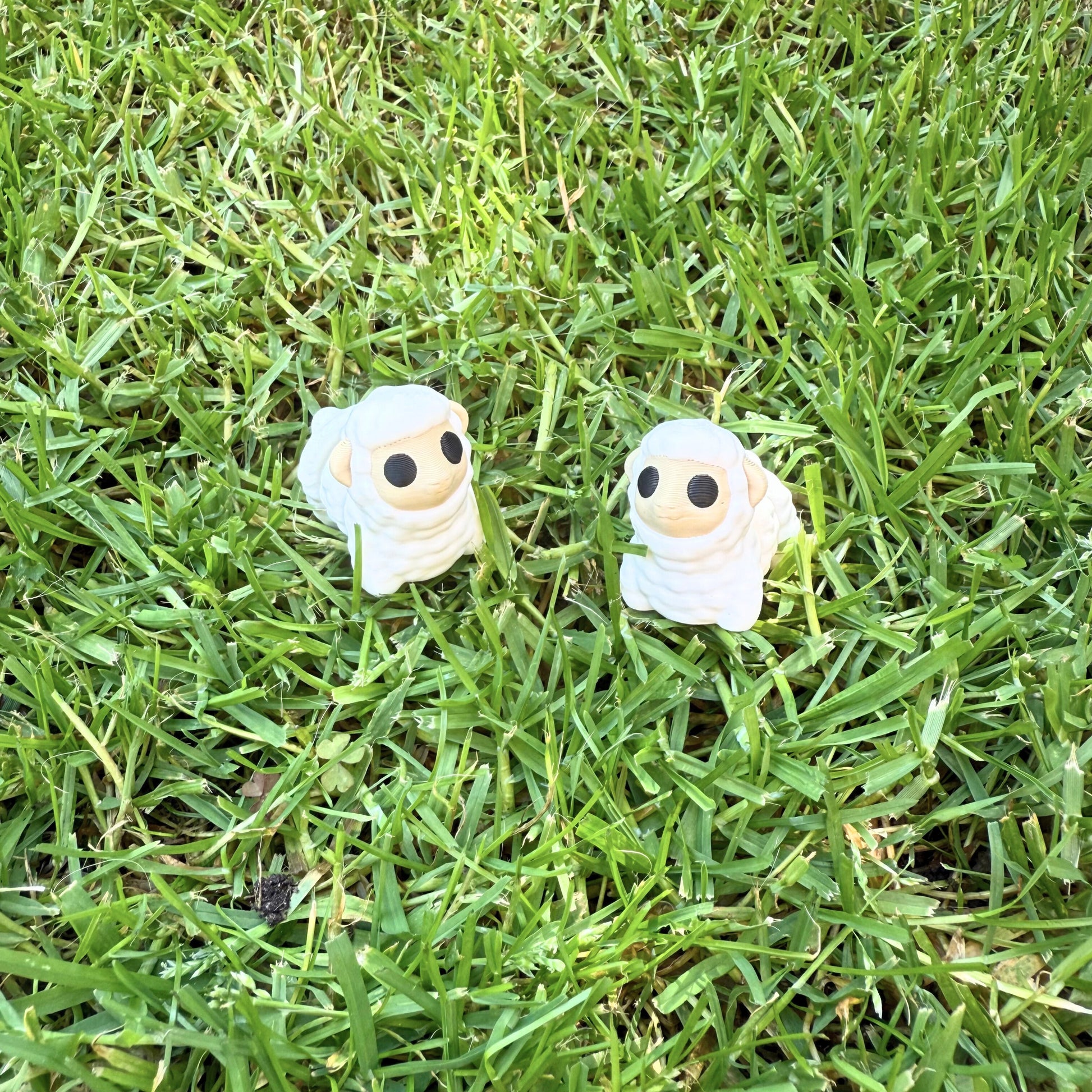 Flexibel model van twee 3D geprinte schaapjes in het gras, speelgoed met beweegbare delen.