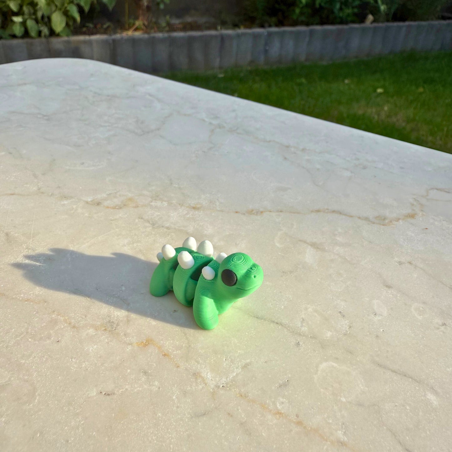 Flexibel model van een 3D geprinte baby stegosaurus, speelgoed met beweegbare delen.
