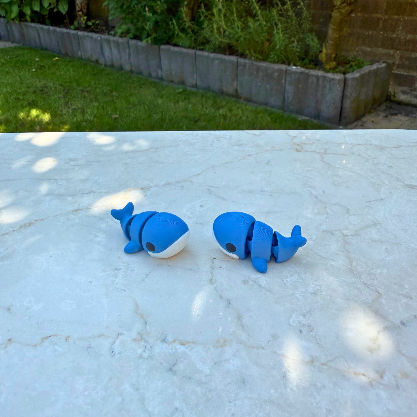 Flexibel model van een 3D geprinte baby walvis, speelgoed met beweegbare delen.