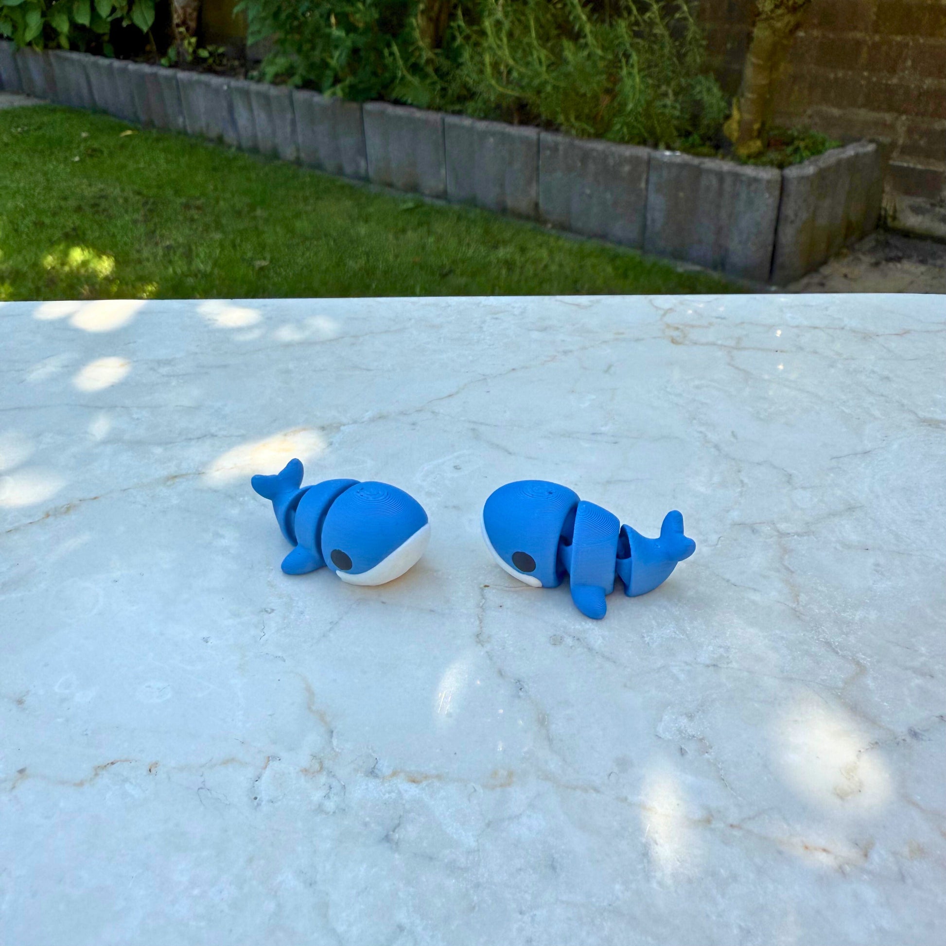 Flexibel model van een 3D geprinte baby walvis, speelgoed met beweegbare delen.